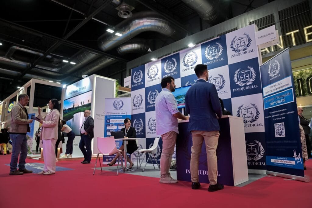Atendiendo a visitantes en el stand de inmojudicial en SIMA